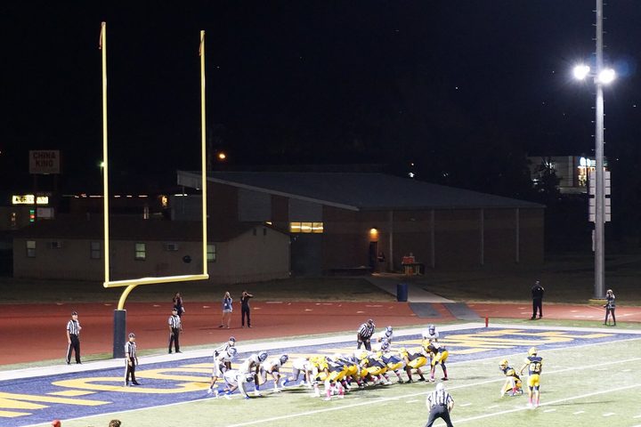 An empty field with the uprights at the far end and the hash marks running out of frame.