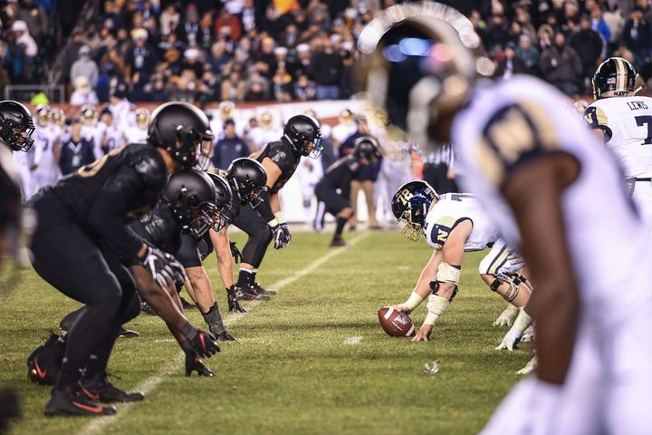 Two lines set a yard apart before the snap, hands down, nobody moving yet.